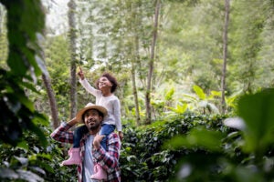 Two children exploring a forest trail surrounded by dense greenery